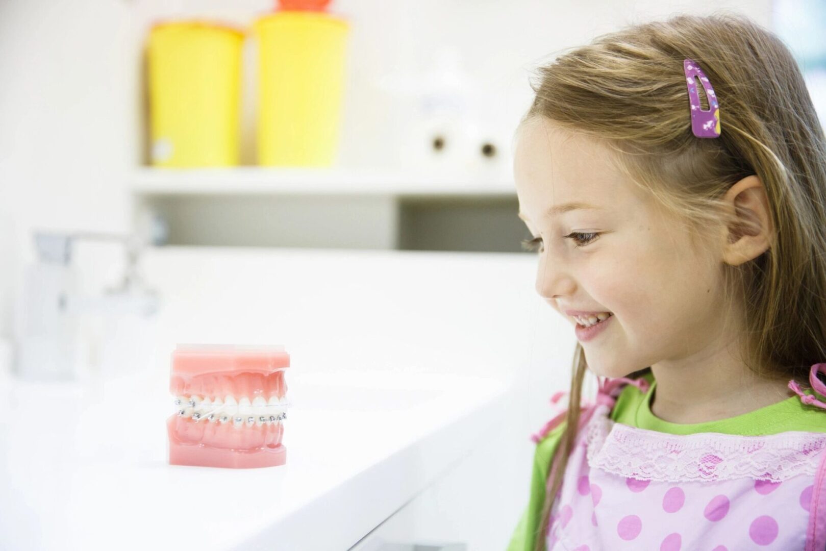 A little girl is smiling at the dentist